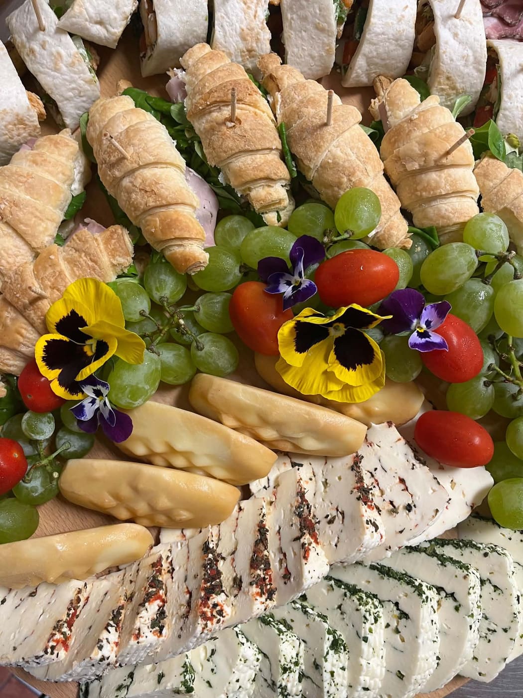 Roladki francuskie, wrapy i świeże owoce na paterze przekąsek